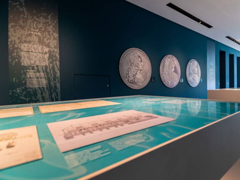 Blick in die Ausstellung mit vergrößerten Münzen an den Wänden